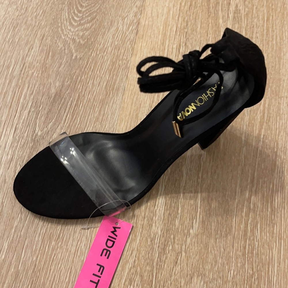 Black heels with clear strap across toe.